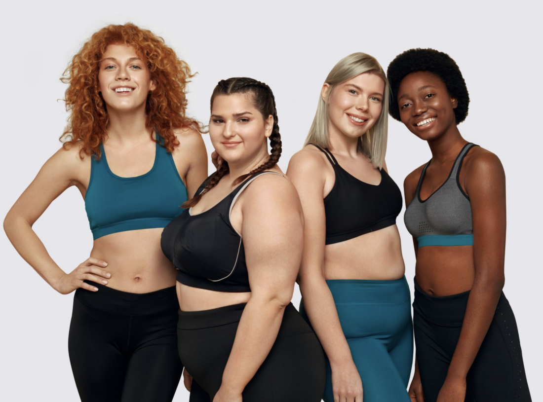 Four women in workout gear promoting body positivity and healthy body composition.